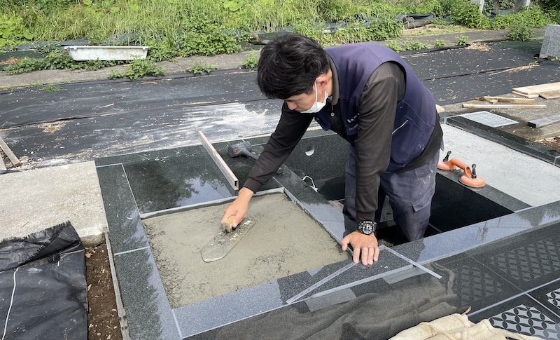 墓地外柵に草が生えない様に石張りにする